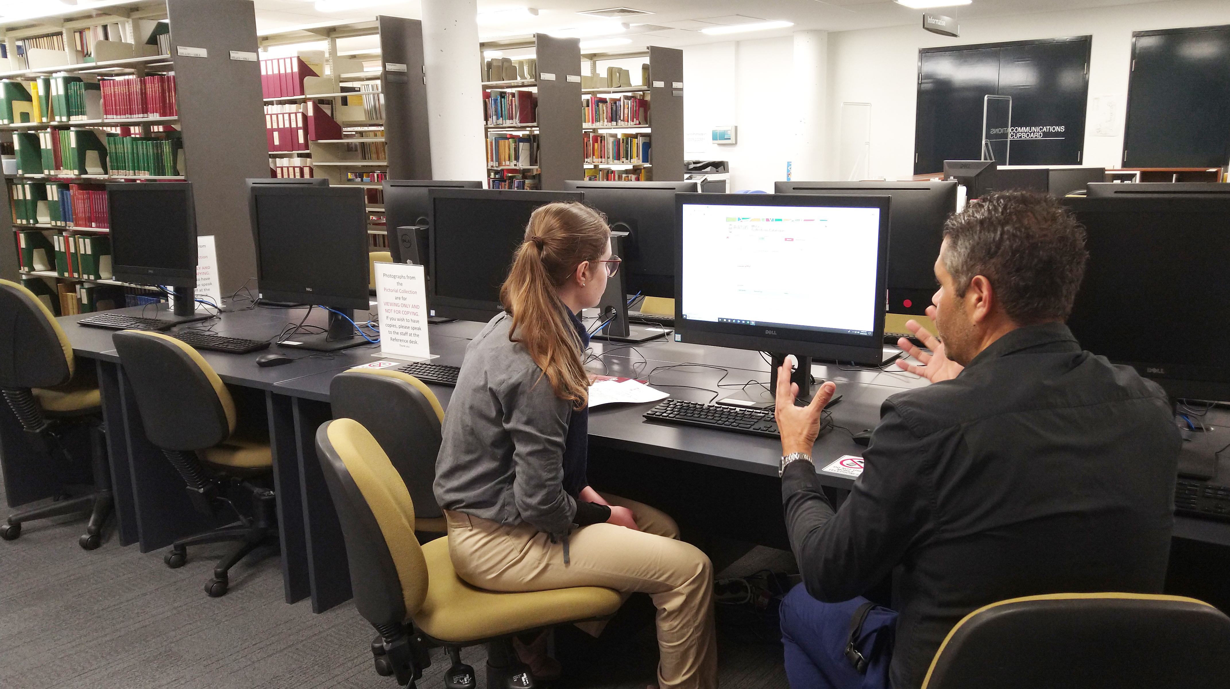PJ Williams is instructing Mia Stone how to use the Mura catalogue in the AIATSIS Library.